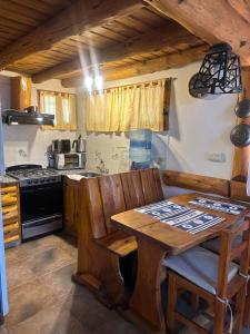 a kitchen with a wooden table and a stove at Casa cuidamos in Mar de las Pampas