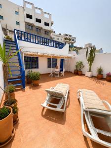 a patio with two lounge chairs and a building at Casa de Hollanda in Sidi Ifni