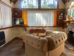 a living room with a couch and a tv at Casa cuidamos in Mar de las Pampas