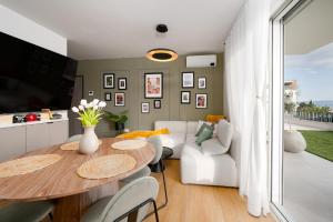 a living room with a table and a couch at Lejla Garden Apartment in Podstrana
