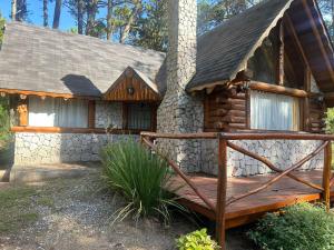 a cabin with a wooden bridge in front of a house at Casa cuidamos in Mar de las Pampas