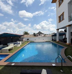 a large swimming pool next to a building at de brit hotel in Benin City