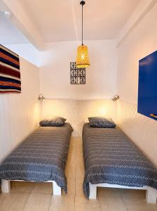 two beds in a room with a tv at Casa de Hollanda in Sidi Ifni