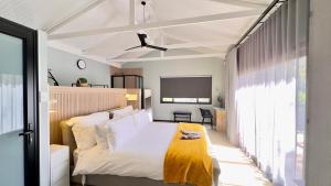 a bedroom with a bed with a yellow blanket on it at Fine Stay Clarens in Clarens