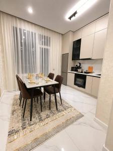 a dining room table and chairs in a kitchen at Olympic Park Apartments near Almaty Arena in Almaty