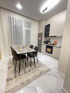 a dining room with a table and chairs in a kitchen at Olympic Park Apartments near Almaty Arena in Almaty +27 photos