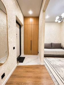 a living room with a couch and a mirror at Olympic Park Apartments near Almaty Arena in Almaty