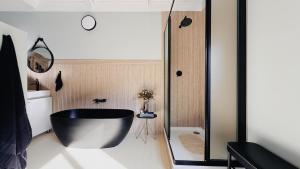 a bathroom with a black tub and a toilet at Fine Stay Clarens in Clarens +15 photos