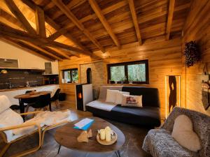 a living room with a couch and a table at Le Chalet Cocon et Jacuzzi in La Petite-Pierre