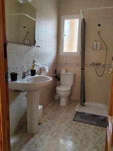 a bathroom with a sink and a toilet and a window at Casa Susan's in Águilas