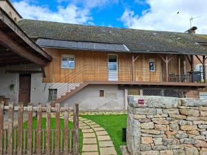 a house with a wooden fence in front of it at Gîte L'alcôve in Issendolus