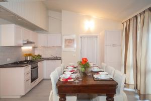 a kitchen with a wooden table with white chairs and a tableablish at La Casa Di Luigi in Gratacasolo