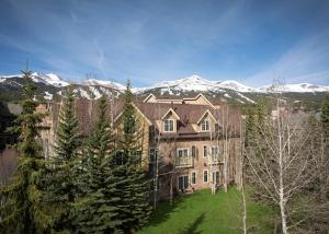 a large building with snow covered mountains in the background at The Residences at Main Street Station by Hyatt Vacation Club in Breckenridge