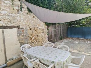 a table and chairs with a white table and a canopy at Cottage Sleeps 2- Pet Friendly WiFi Free Parking in Montauriol
