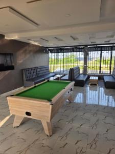 a living room with a pool table and couches at KayQuin Garden in Warri