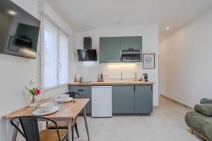 a kitchen and dining room with a table and chairs at Le Clos de Vaires in Vaires-sur-Marne