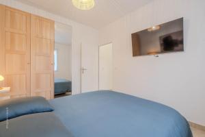 a bedroom with a bed and a tv on the wall at Le Clos de Vaires in Vaires-sur-Marne