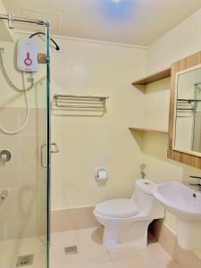 a bathroom with a toilet and a sink and a shower at Ilo2stayAirbnb 1BR Luna in Iloilo City +12 photos