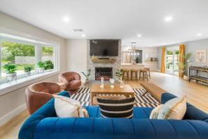 a living room with a blue couch and a fireplace at Cape Cod heated Pool, Putting Green, Speak Easy, Game room, in Harwich