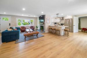 a living room with a blue couch and a kitchen at Cape Cod heated Pool, Putting Green, Speak Easy, Game room, in Harwich