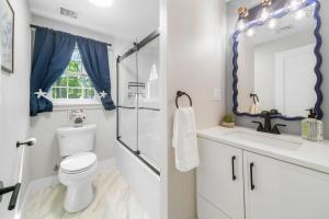 a bathroom with a toilet and a sink and a shower at Cape Cod heated Pool, Putting Green, Speak Easy, Game room, in Harwich +53 photos