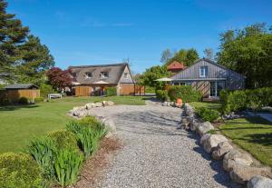 a yard with a house and a gravel driveway at Reethaus M - Sommerhaus 54 in Grödersby