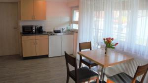 a kitchen with a table and chairs and a kitchen with a dining room at Wein- Appartements Borth in Bretzfeld