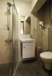 a bathroom with a toilet and a sink and a shower at Goren Hotel in Çeşme +25 photos