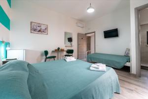 a hotel room with a green bed and a desk at Perla Marina Rooms in Realmonte