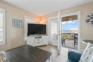 a living room with a television and a balcony at 3 BDR, Oceanview's, Walk to Pier in Carolina Beach