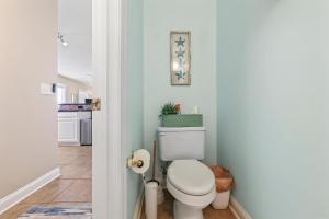 a bathroom with a white toilet in a hallway at 3 BDR, Oceanview's, Walk to Pier in Carolina Beach +28 photos