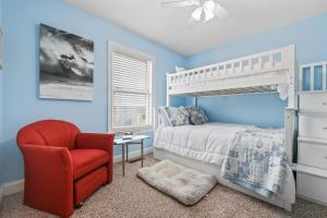 a bedroom with a white bed and a red chair at 3 BDR, Oceanview's, Walk to Pier in Carolina Beach