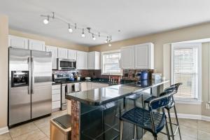 a kitchen with stainless steel appliances and white cabinets at 3 BDR, Oceanview's, Walk to Pier in Carolina Beach