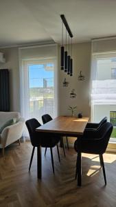 a dining room with a wooden table and chairs at Jeziorna Premium Apartment in Siewierz