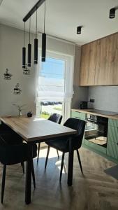a dining room with a table and chairs in a kitchen at Jeziorna Premium Apartment in Siewierz