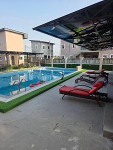 a large swimming pool with chairs and a canopy at KayQuin Garden in Warri