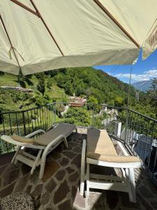a patio with two chairs and an umbrella on a balcony at Ca Vecia in Gargnano