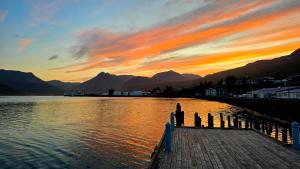 a sunset over a body of water with mountains at Cozy Fjord Loft in Reyðarfjörður +17 photos