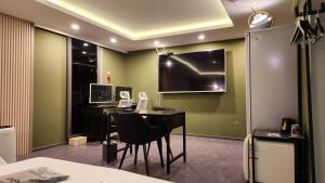 a room with a desk with chairs and a monitor at Hotel166 in Suwon