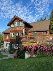 a house with flowers in front of it at Ferienwohnung Gaiswinkler in Grundlsee