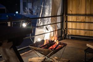a person is cooking over a fire in a room at Jade Byeolbit Caravan in Chuncheon