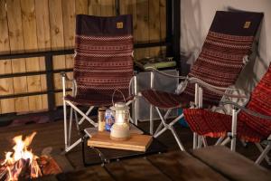 a couple of chairs sitting next to a fire at Jade Byeolbit Caravan in Chuncheon +12 photos