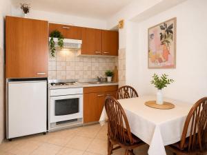 a kitchen with a table and a white refrigerator at Sunshine in Cavtat