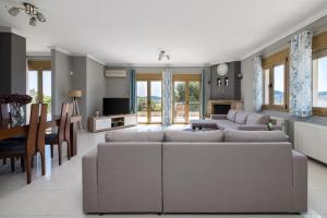 a living room with a couch and a dining room at Villa Granero by Booking Kottas in Kassandra