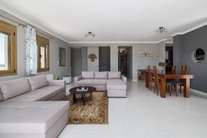a living room with two couches and a table at Villa Granero by Booking Kottas in Kassandra
