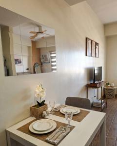 a kitchen with a table with plates and a mirror at Studio 7C at One Regis in Bacolod
