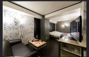 a small room with a couch and a bed at ホテルヴェローナ in Yokohama
