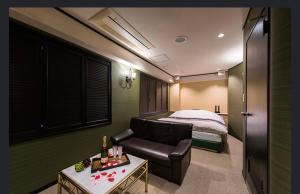 a hotel room with a couch and a bed at ホテルヴェローナ in Yokohama +1 photo