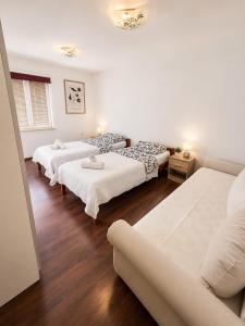 a room with three beds and a couch at Sunshine in Cavtat