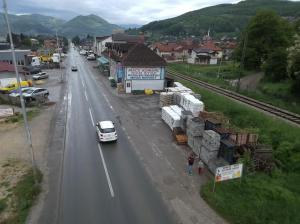 a white car driving down a street with a building at Motel MEČE in Bijelo Polje +16 photos